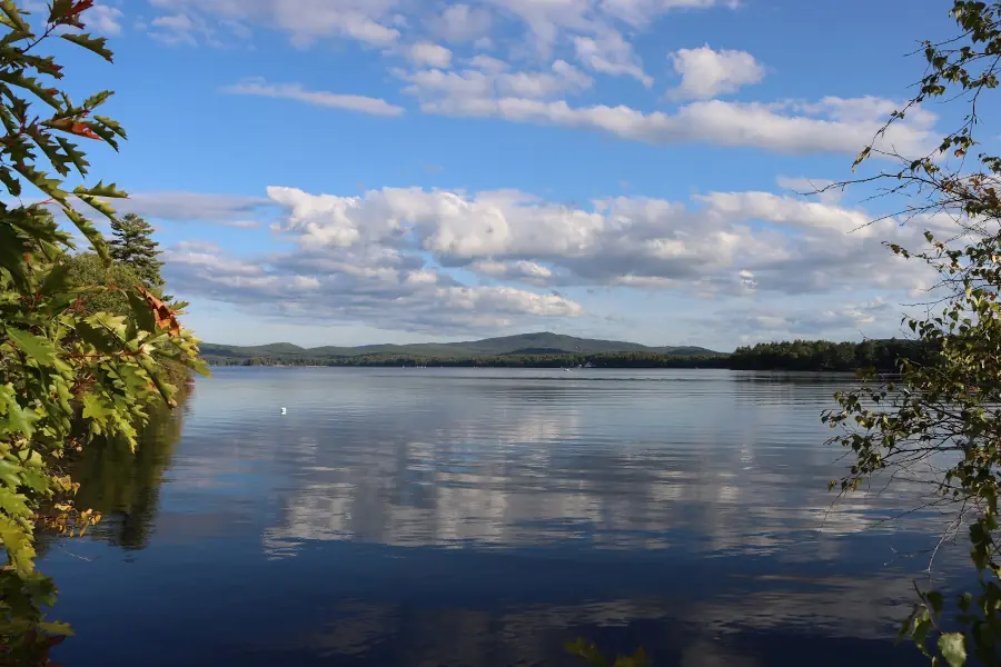 A panoramic view of a tranquil lake in the late afternoon.
