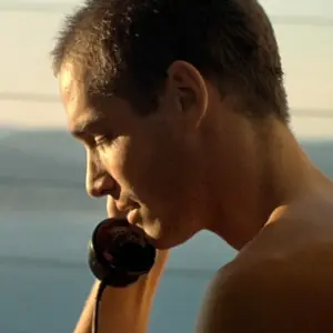 Jack, from the film, talking on the phone with Joanna. The ocean is in the background.